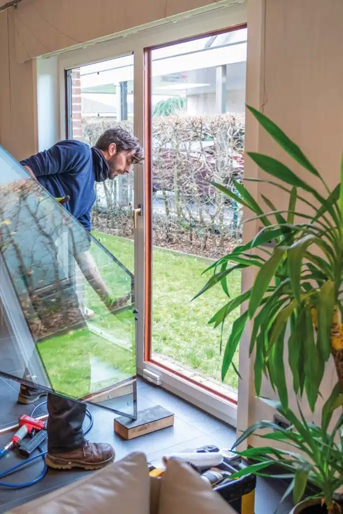 Man vervangt glazen ruit in een woning