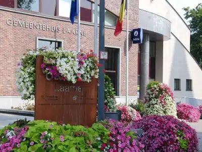 Gemeentehuis Laarne met bloemen en vlaggen - informatie over gemeentelijke woonpremies