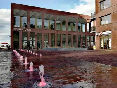 Gemeentehuis Wetteren met moderne glazen gevel en fontein op het plein - gemeentelijke premies en steunmaatregelen